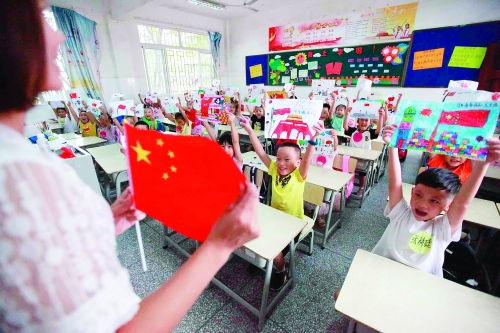 穿山小学组织一年级的学生绘制爱国主题的图画,老师为孩子们讲解